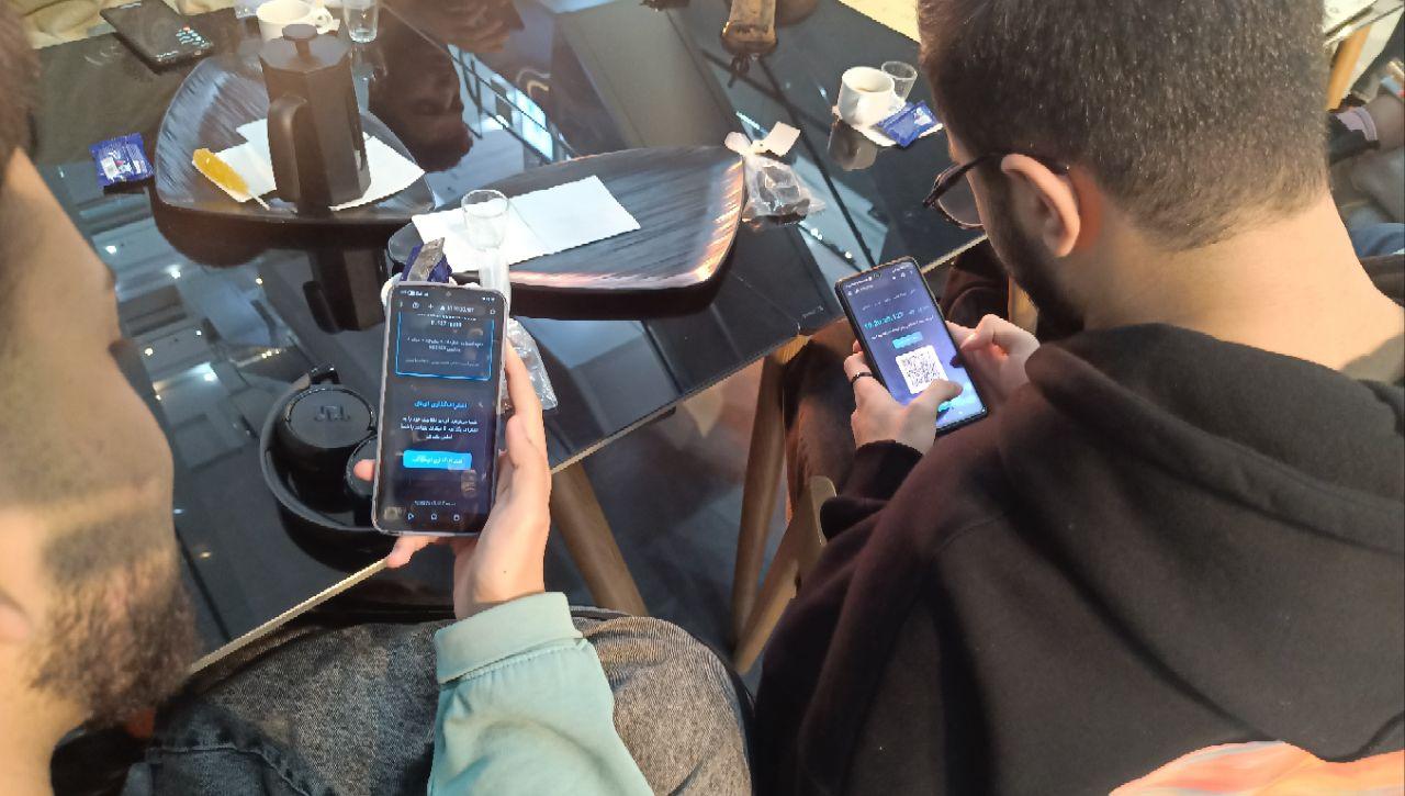 Two people at a private free software community gathering, testing and registering DeltaChat servers on their mobile phones