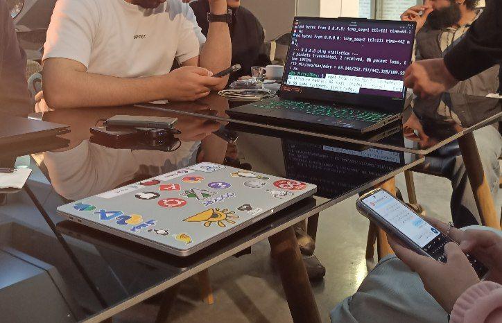 A laptop on a table, displaying a command line interface for installing a DeltaChat server.